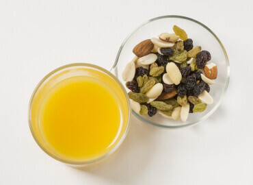 Glass of fresh orange juice Mixed nuts and raisins