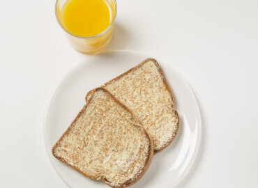 Glass of fresh orange juice with 2 slices of wholemeal toast with lower fat spread