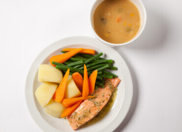 Bowl of tinned lentil soup, and salmon with potatoes and vegetables