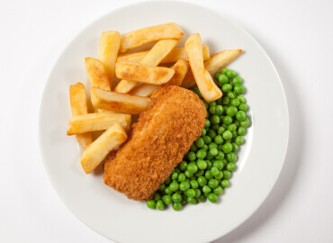 Oven baked haddock with oven chips and vegetables